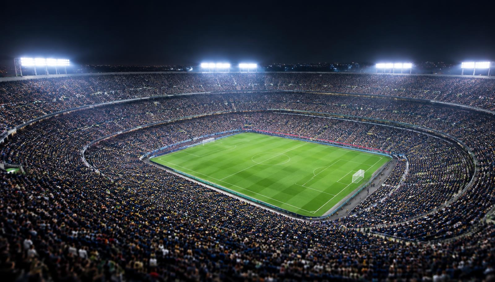 Packed stadium crowd seen from far away under bright night lights